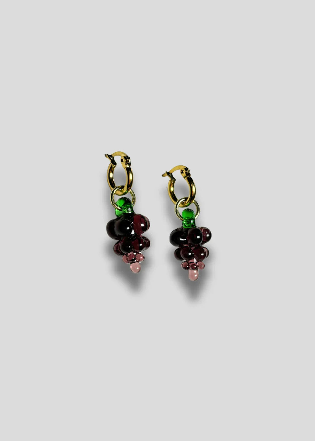 A pair of Vino Hoops glass grape earrings with gold vermeil hooks, featuring handcrafted glass grapes in green and red colors.